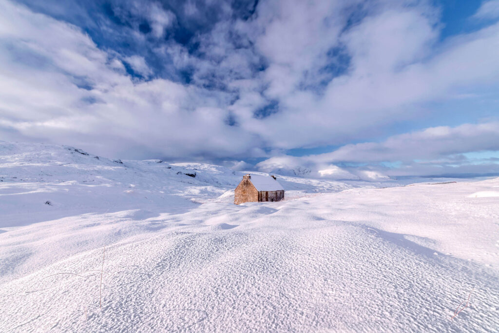 Photo of Dundonneell Bothy in winter snow, Scotland.